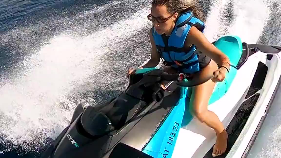 Chica pilotando una moto de agua Sea-Doo a toda velocidad frente a la costa de Alicante