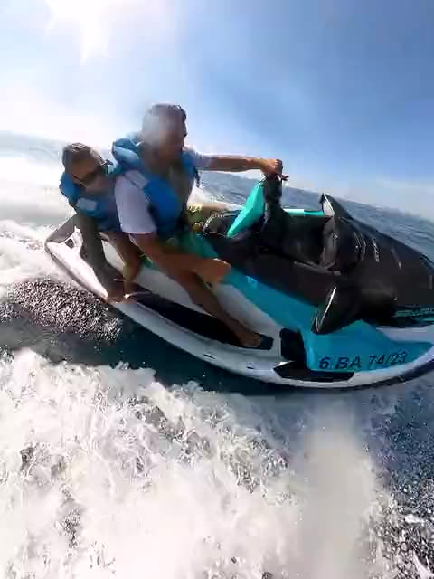Dos pasajeros sobre una moto de agua entre la espuma